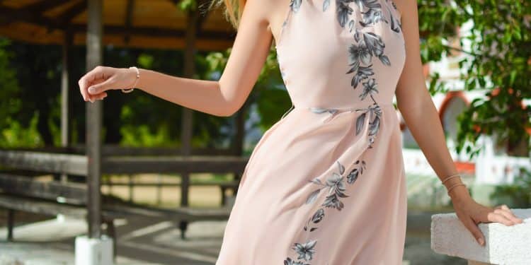 woman wearing pink, black, and white floral halter-top dress