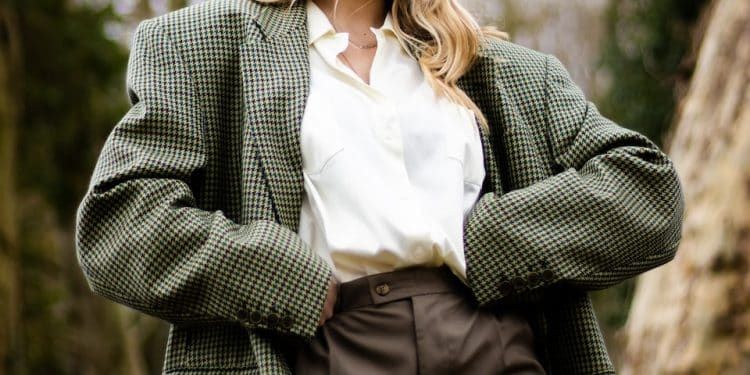 woman in gray and white polka dot blazer standing and smiling