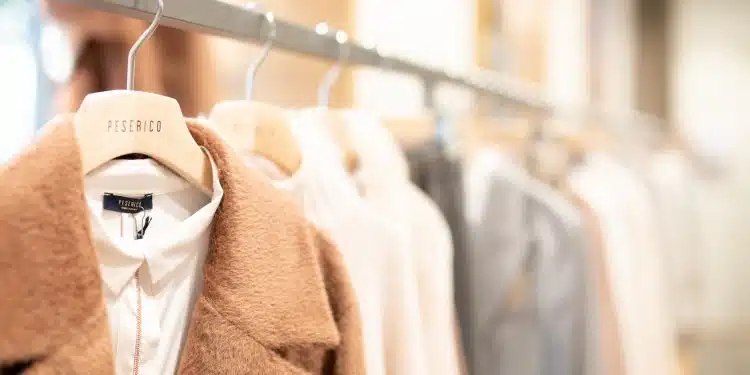 brown coat hanged on white plastic hanger